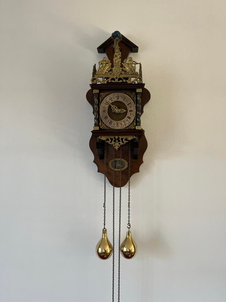 Zaanse klok notenhout met messing ornamenten (Warmink), Ophalen