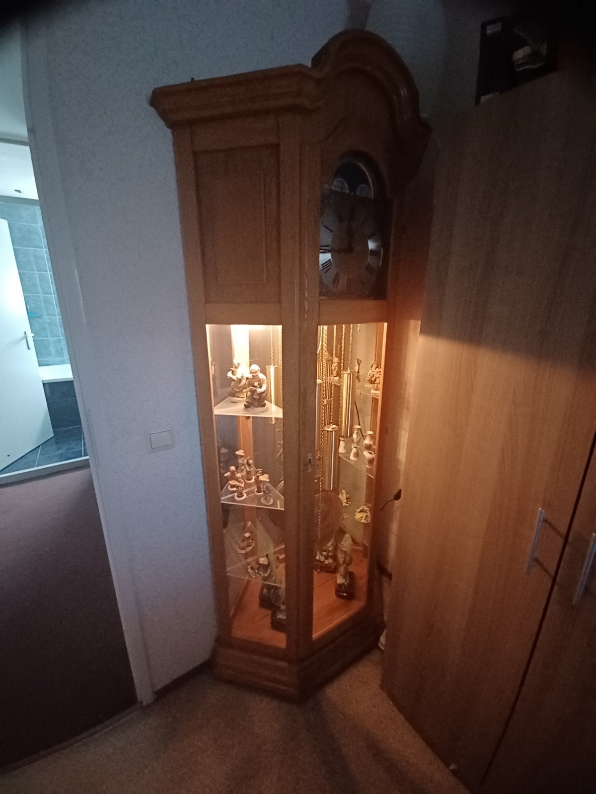 Staande klok met vitrinekast en verlichting, Ophalen