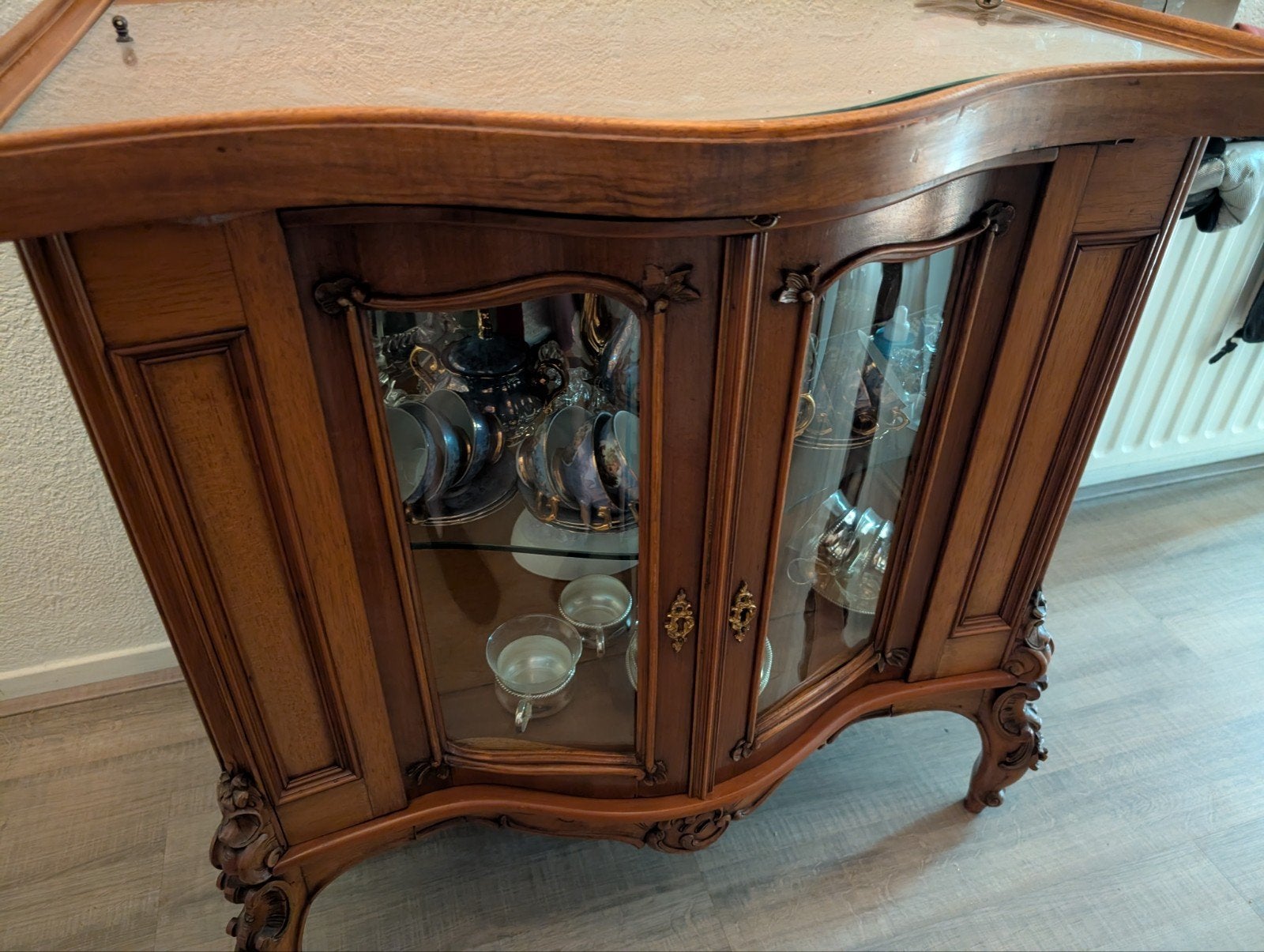 Antieke vitrinekast met sierlijke details, Ophalen