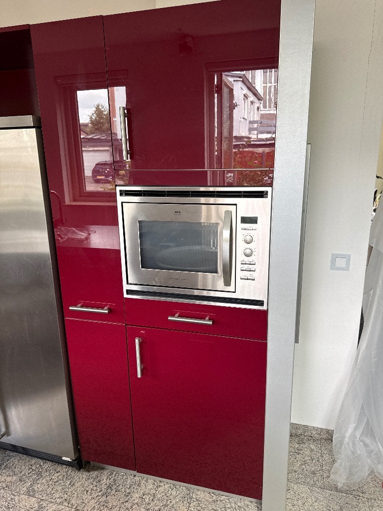 Moderne rode keuken met kookeiland en diverse apparatuur
