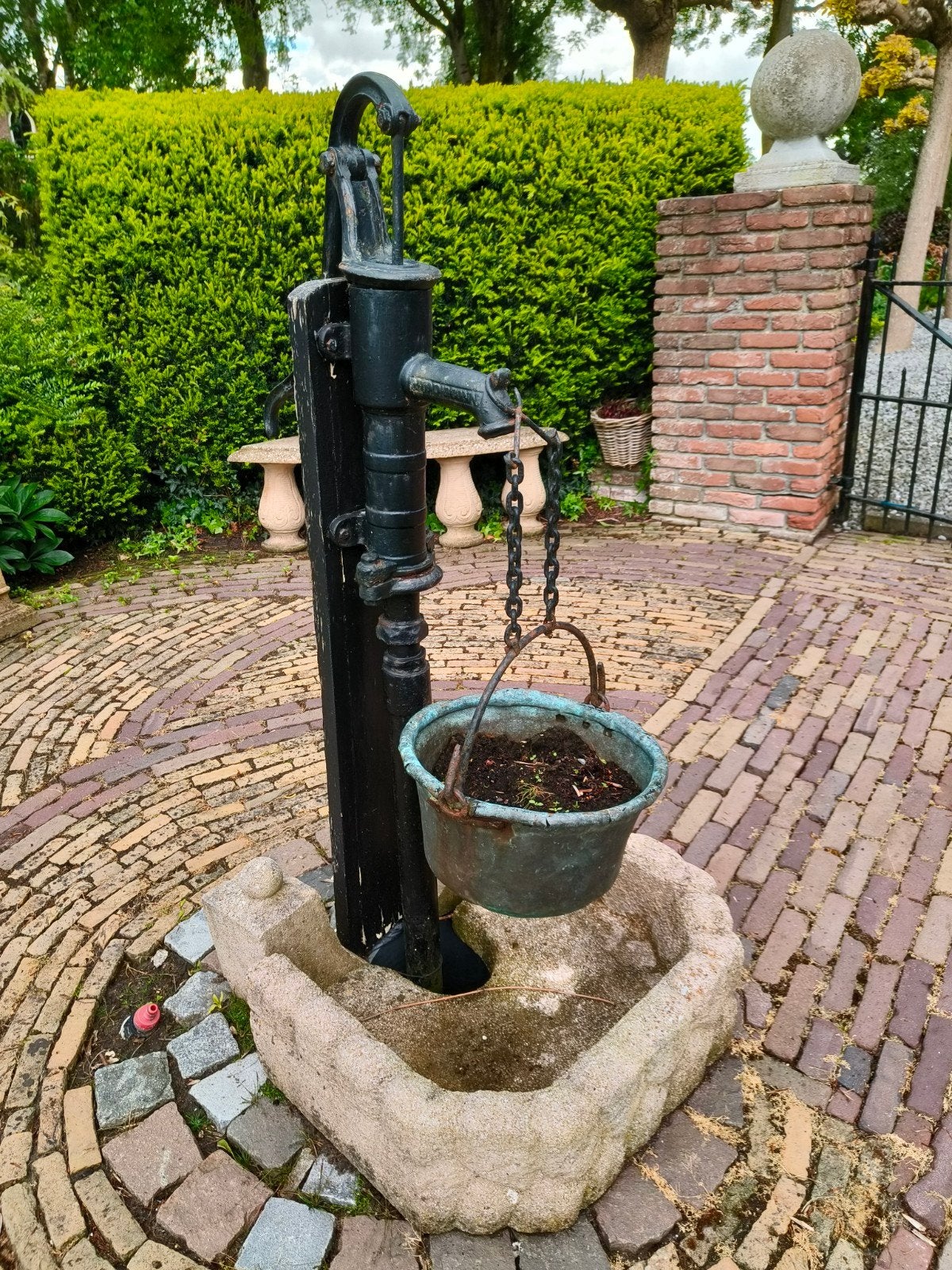 Antieke gietijzeren waterpomp met stenen bak, Ophalen, Gebruikt