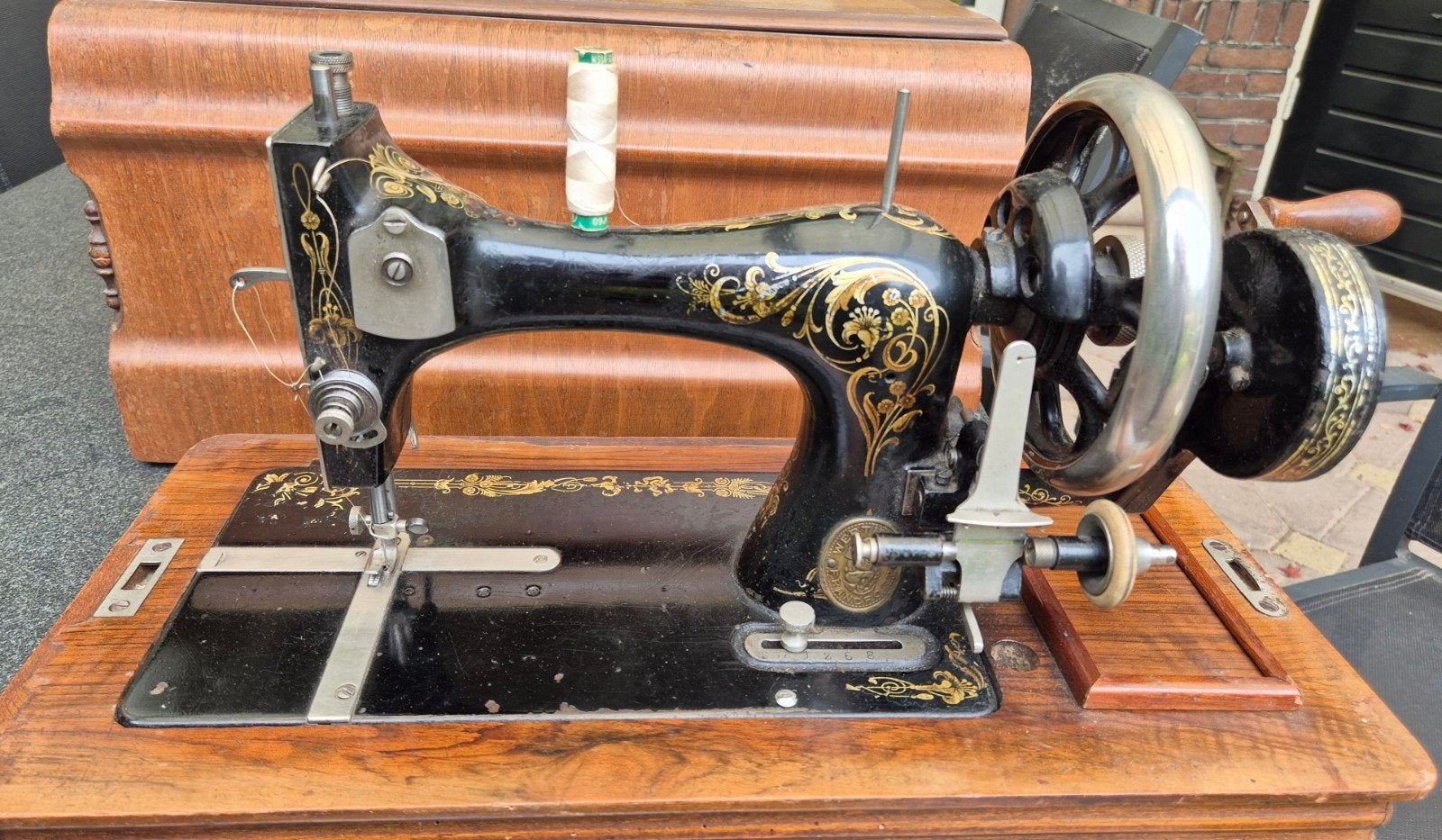 Antieke handnaaimachine met houten koffer, Ophalen