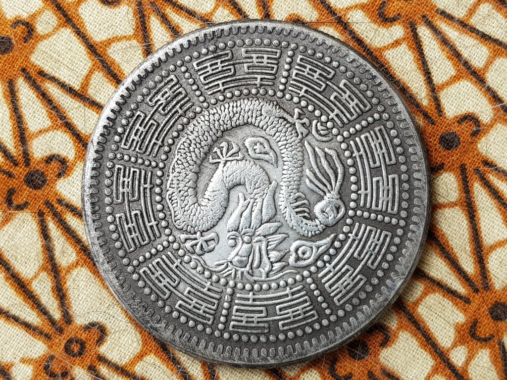 Mooie zilverbrons penning met draak en karakters uit China.