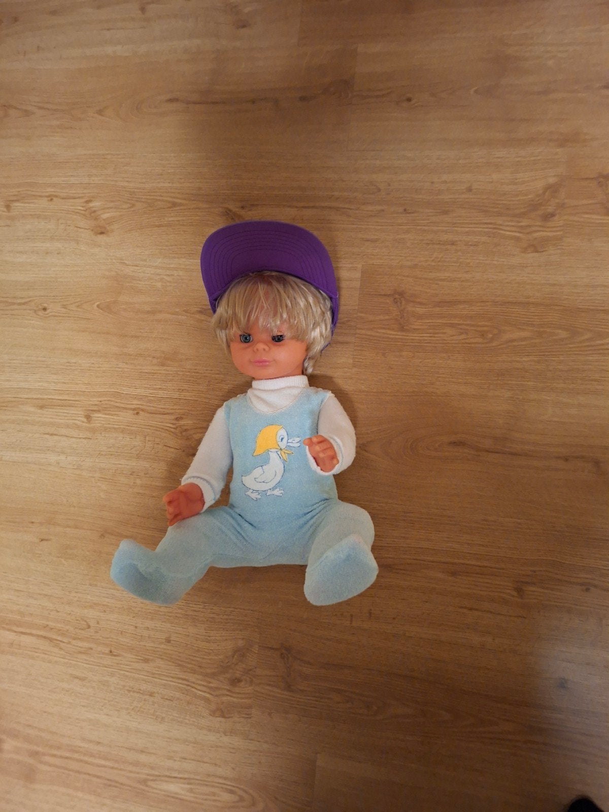 Vintage Babypop met paarse pet en eendje-overall, Ophalen