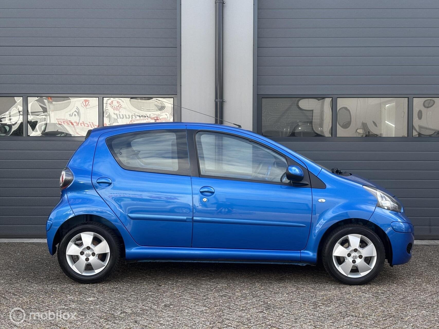 Toyota Aygo 1.0-12V Dynamic Blue Uitvoering / 5DRS, Voorwielaandrijving, Metallic lak, 68 pk, Bedrijf