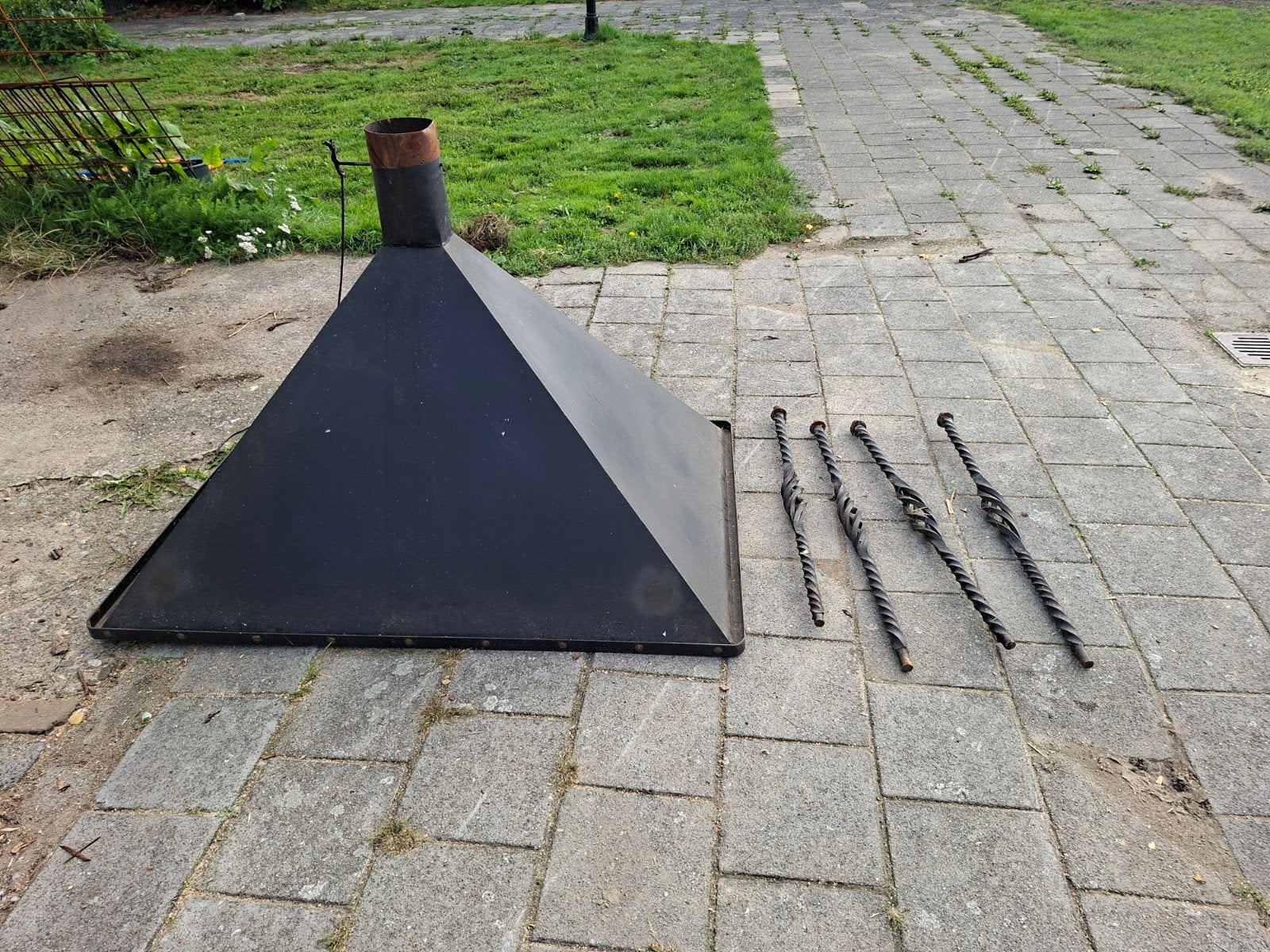 Zwarte afzuigkap met smeedijzeren steunen.