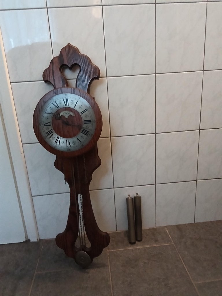 Antieke wandklok met slinger en gewichten, Ophalen