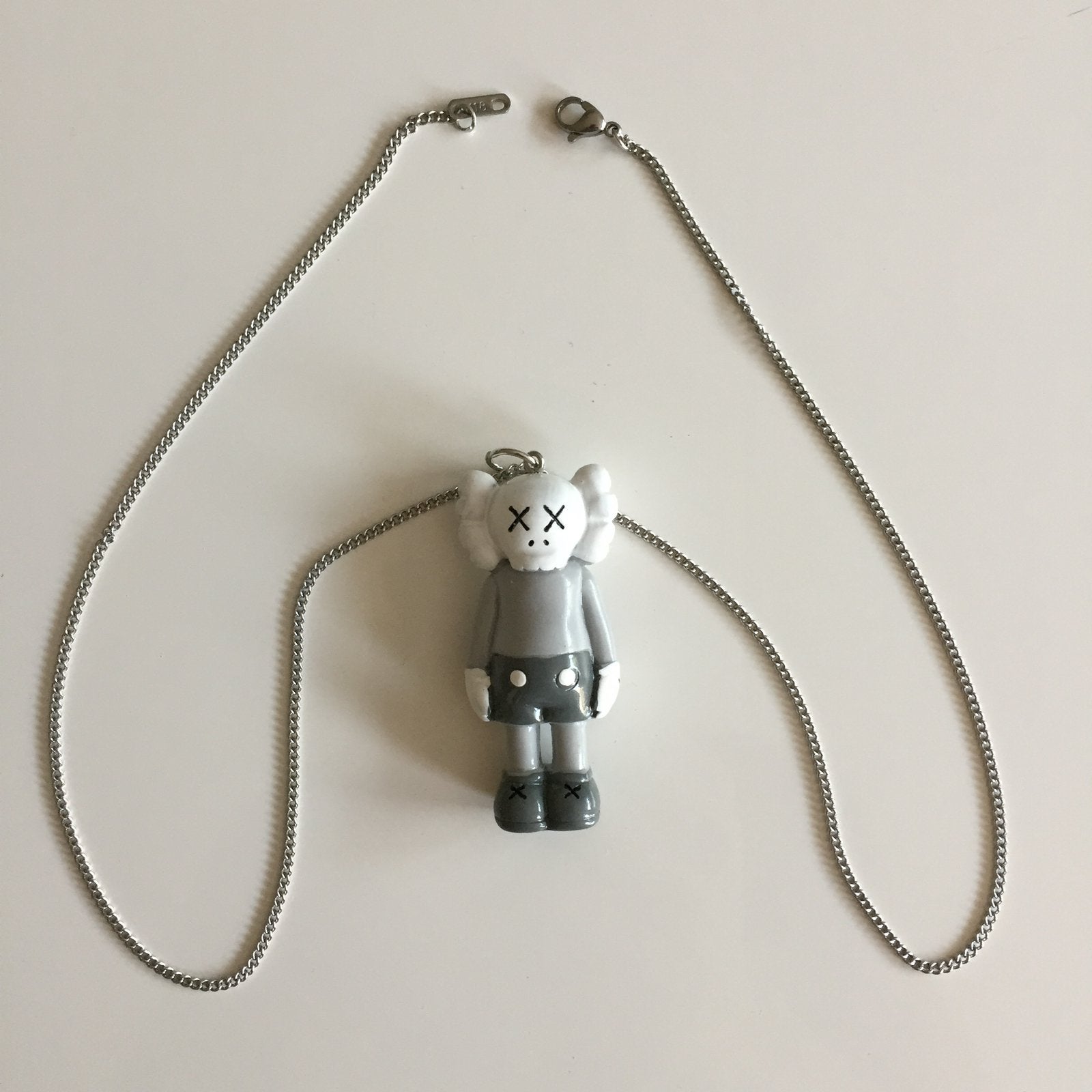Lange ketting 60 cm met grijs kaws pop kettinghanger, Sieraden, Tassen en Uiterlijk, Kettingen, Ophalen of Verzenden, Nieuw, Grijs