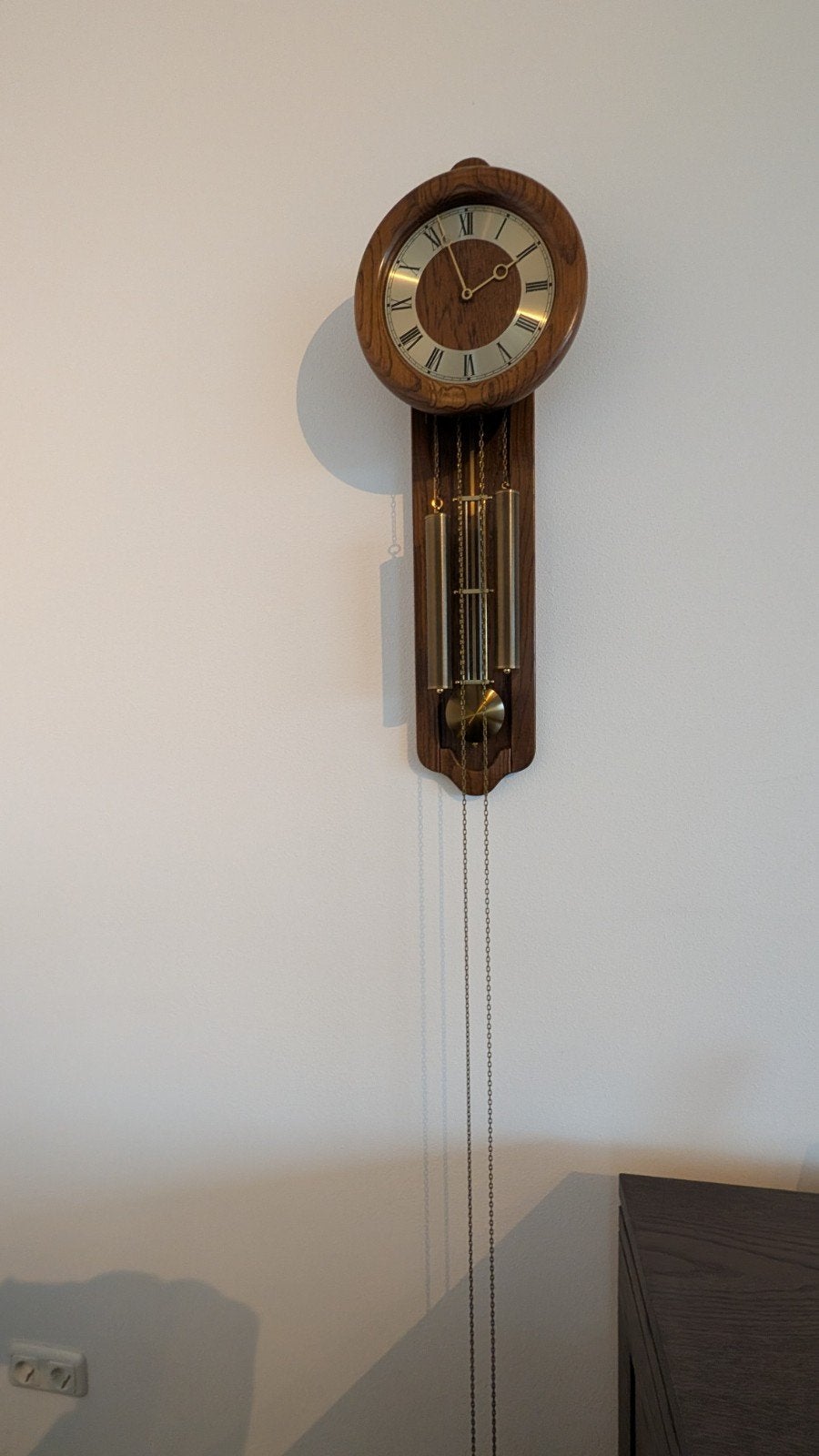 Wandklok met slinger en kettingen, Ophalen
