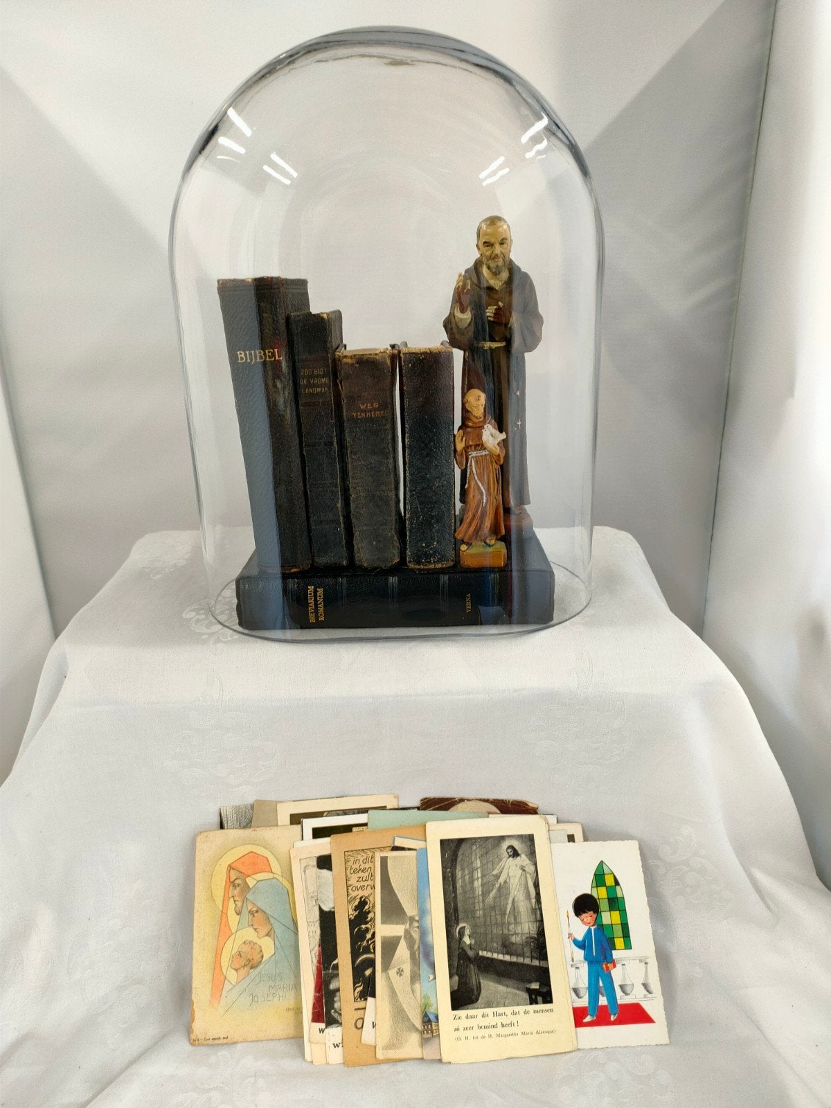 Glazen stolp met religieuze boeken en beelden, Antiek en Kunst, Antiek | Religie, Ophalen of Verzenden