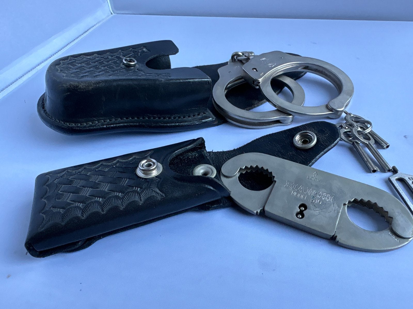 Handboeien en duimboeien set met lederen houders, Verzamelen, Militaria | Algemeen, Ophalen of Verzenden, Overige soorten, Amerika