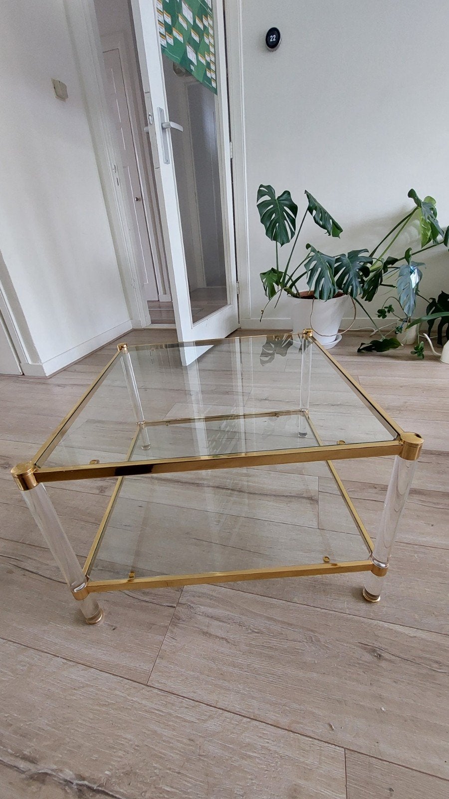 Glazen salontafel met gouden frame en acryl poten, Huis en Inrichting, Tafels | Salontafels, Ophalen, Gebruikt, 50 tot 100 cm