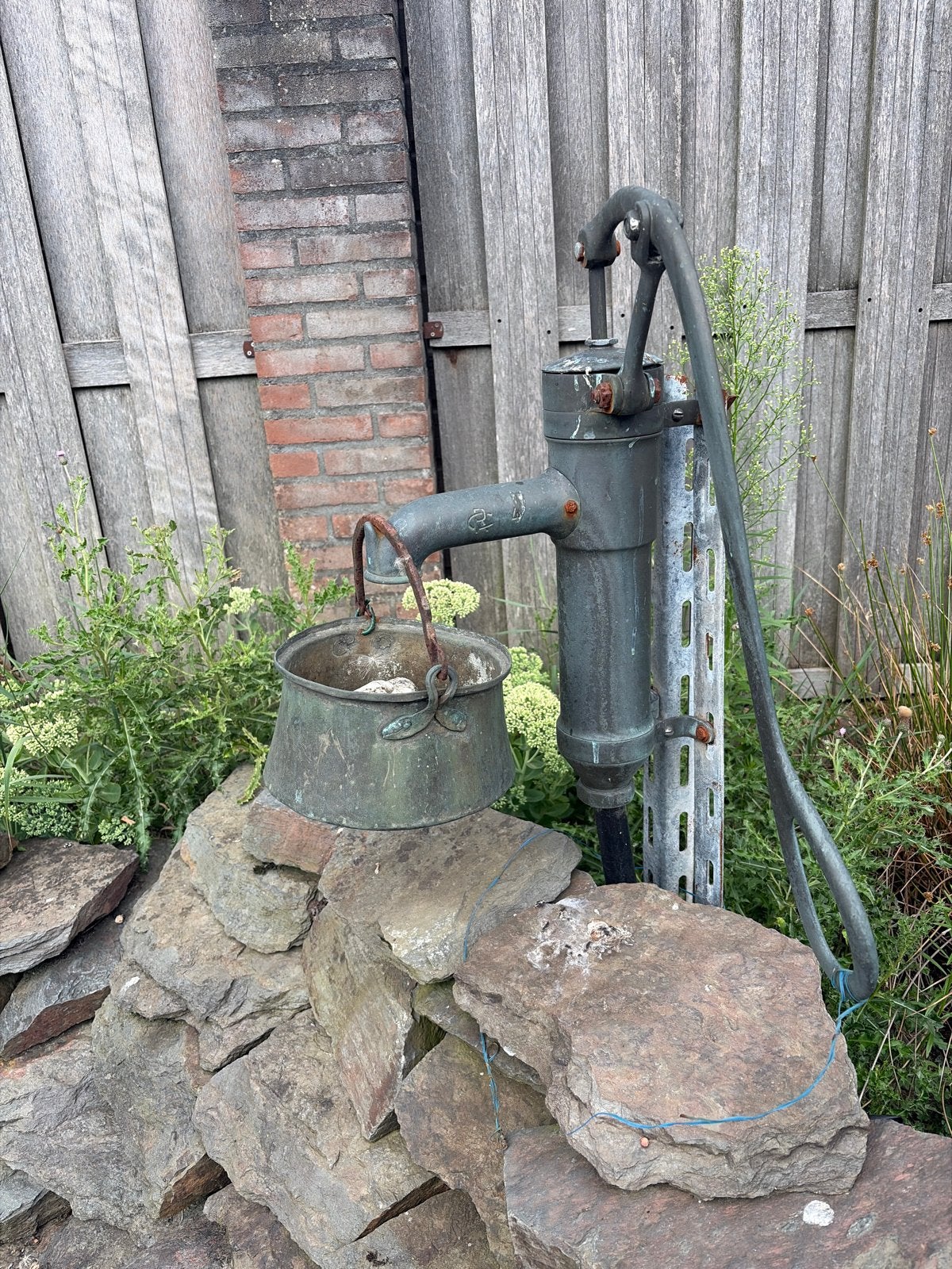 Antieke gietijzeren CR handwaterpomp met emmer, Ophalen
