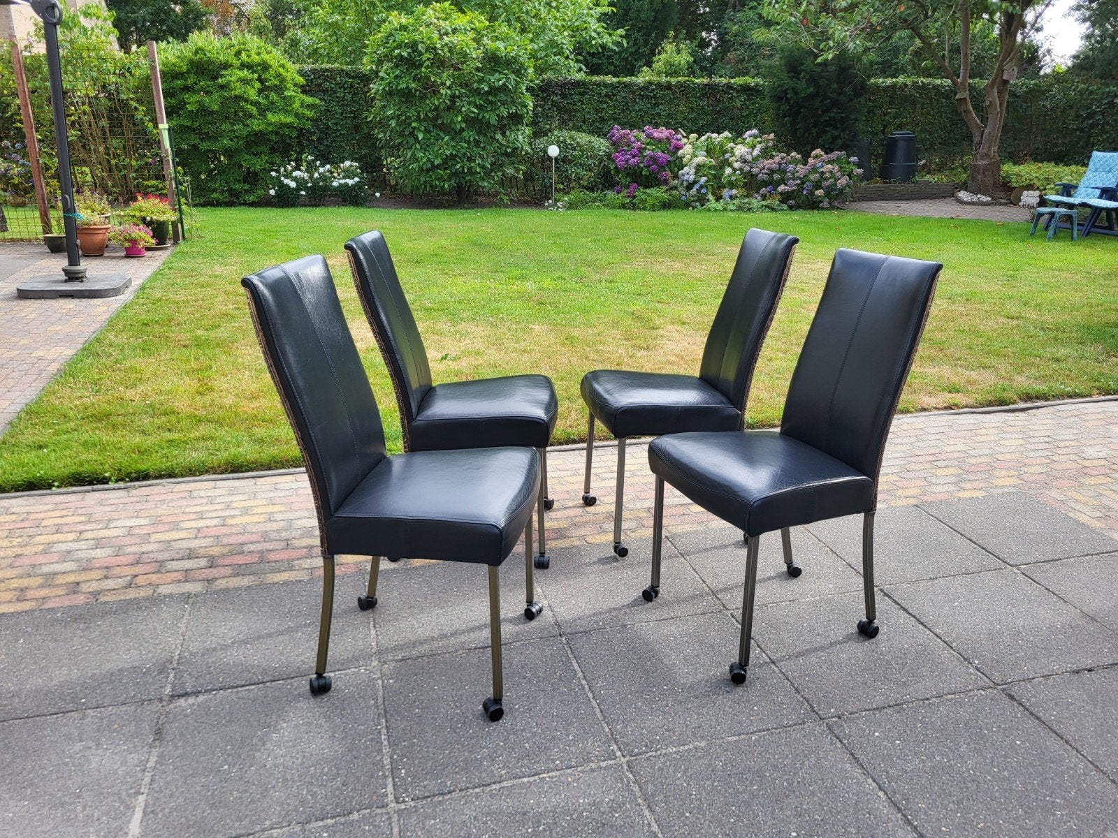 4 of 6 Bert Plantagie eetkamerstoelen + wielen, zwart leer, Ophalen, Zwart, Leer, Zo goed als nieuw