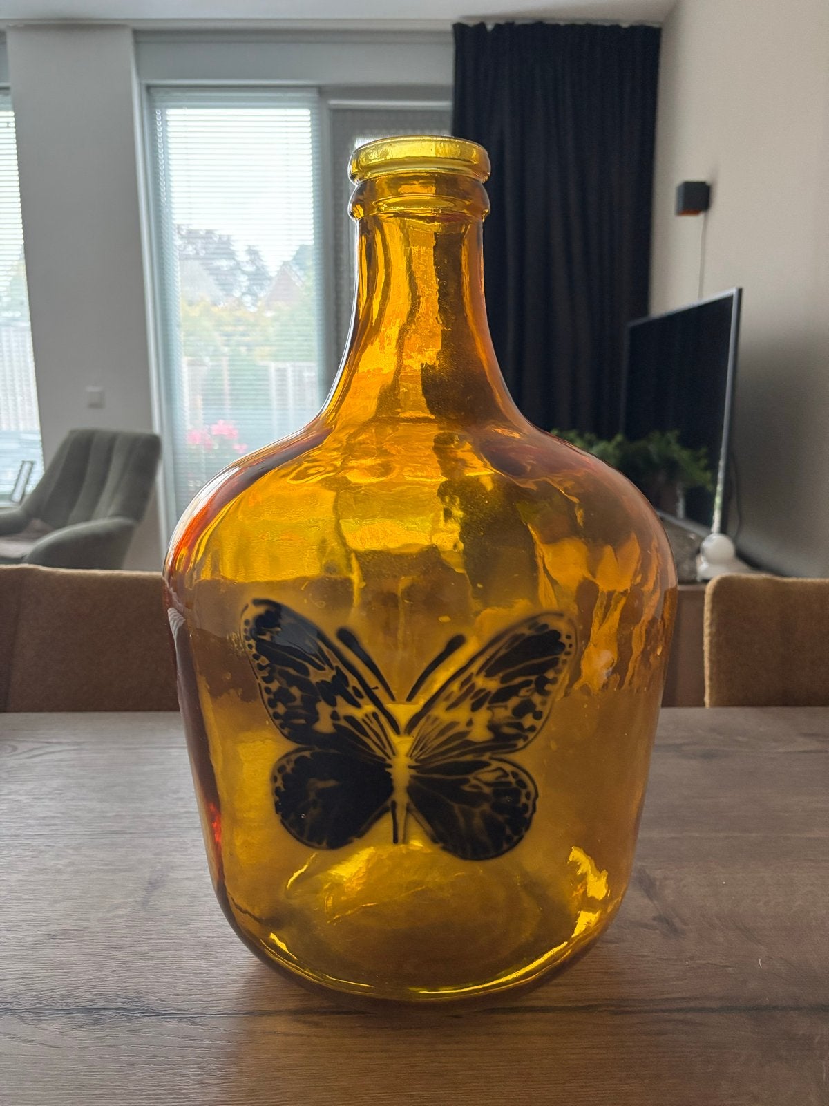 Grote oker gele glazen fles met vlinderdecoratie, Huis en Inrichting, Ophalen