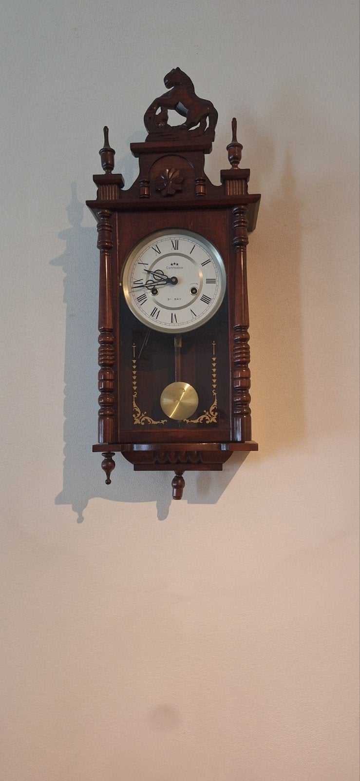 Antieke wandklok met slinger en houtsnijwerk, Ophalen