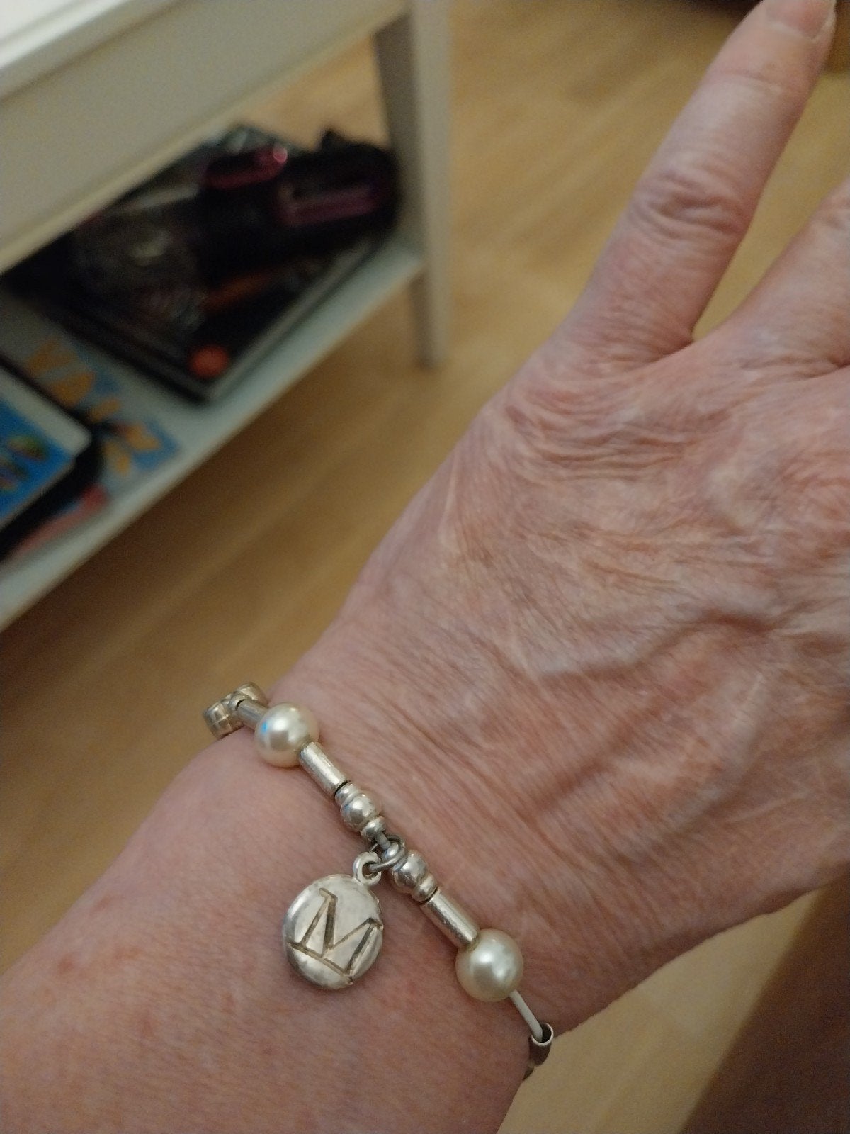 Zilveren armband met parels en bedel 'M', Nieuw, Ophalen of Verzenden, Elastiek, Met bedels of kralen