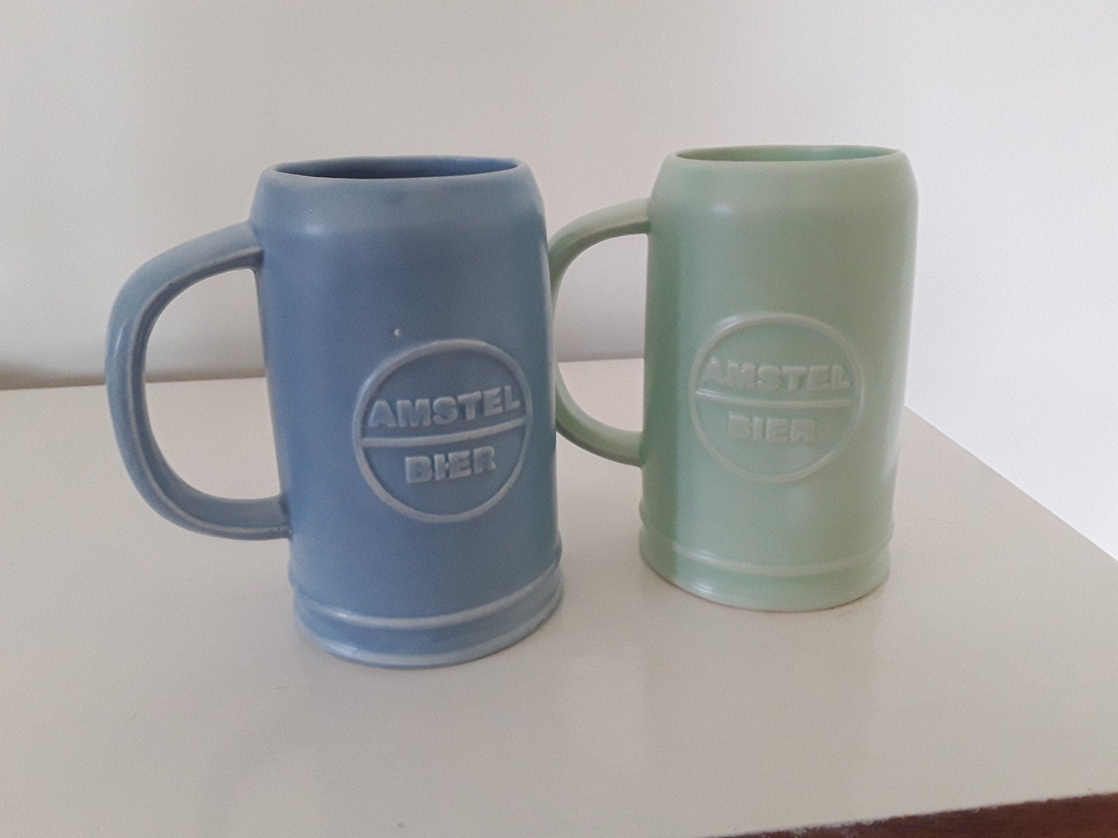 Set aardewerken bierpullen Amstel bier, blauw en groen, Ophalen of Verzenden, Zo goed als nieuw, Overige stijlen, Kop(pen) en/of Schotel(s)