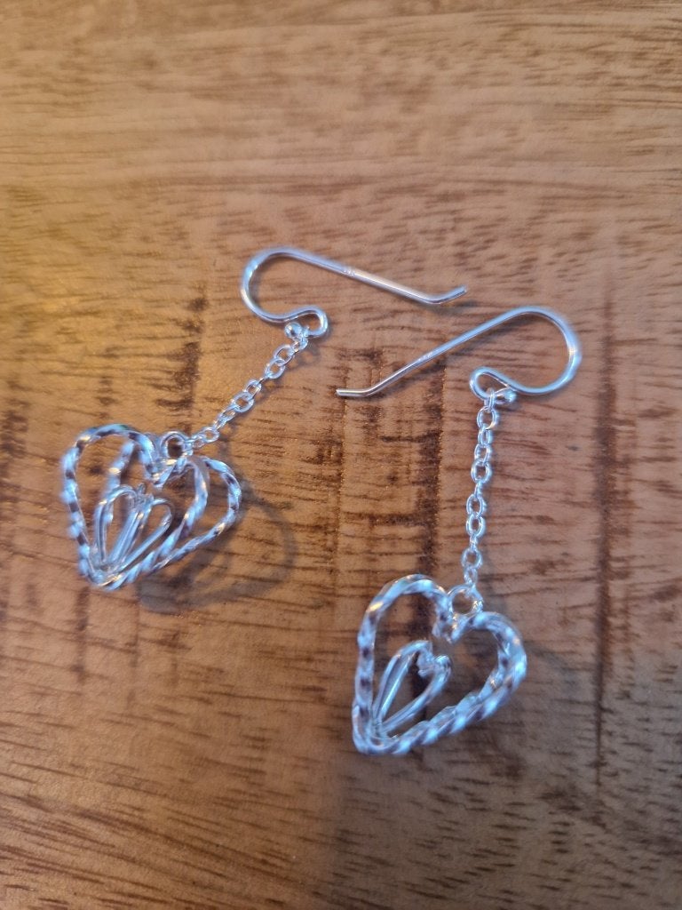 Oude, zilveren oorbellen. Hart in hart.