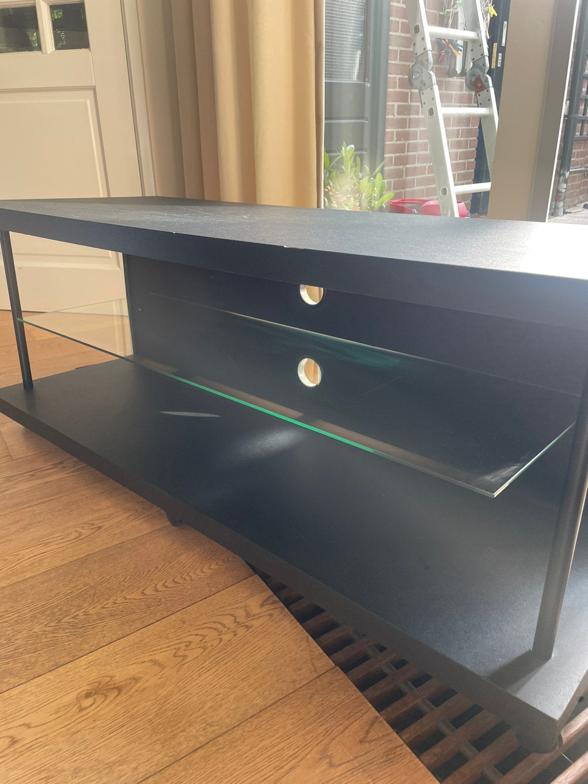 Zwart TV meubel met glazen plaat en op wieltjes, Huis en Inrichting, Kasten | Televisiemeubels, Ophalen, Gebruikt, 100 tot 150 cm