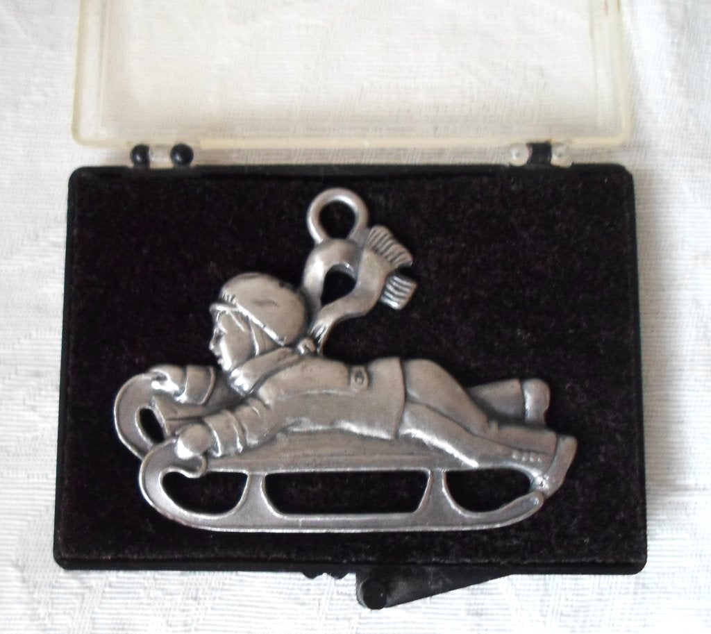 Tinnen hanger jongen op slee in originele doos., Antiek en Kunst, Ophalen of Verzenden