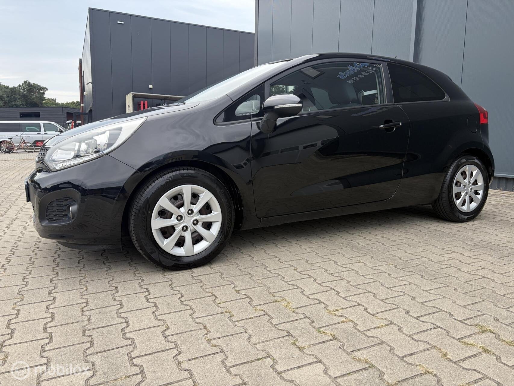 Kia Rio 1.2 CVVT Plus Pack Airco Nieuwe Apk 1ste Eigenaar, Auto's, Euro 5, Zwart, 4 cilinders, Elektrische ramen