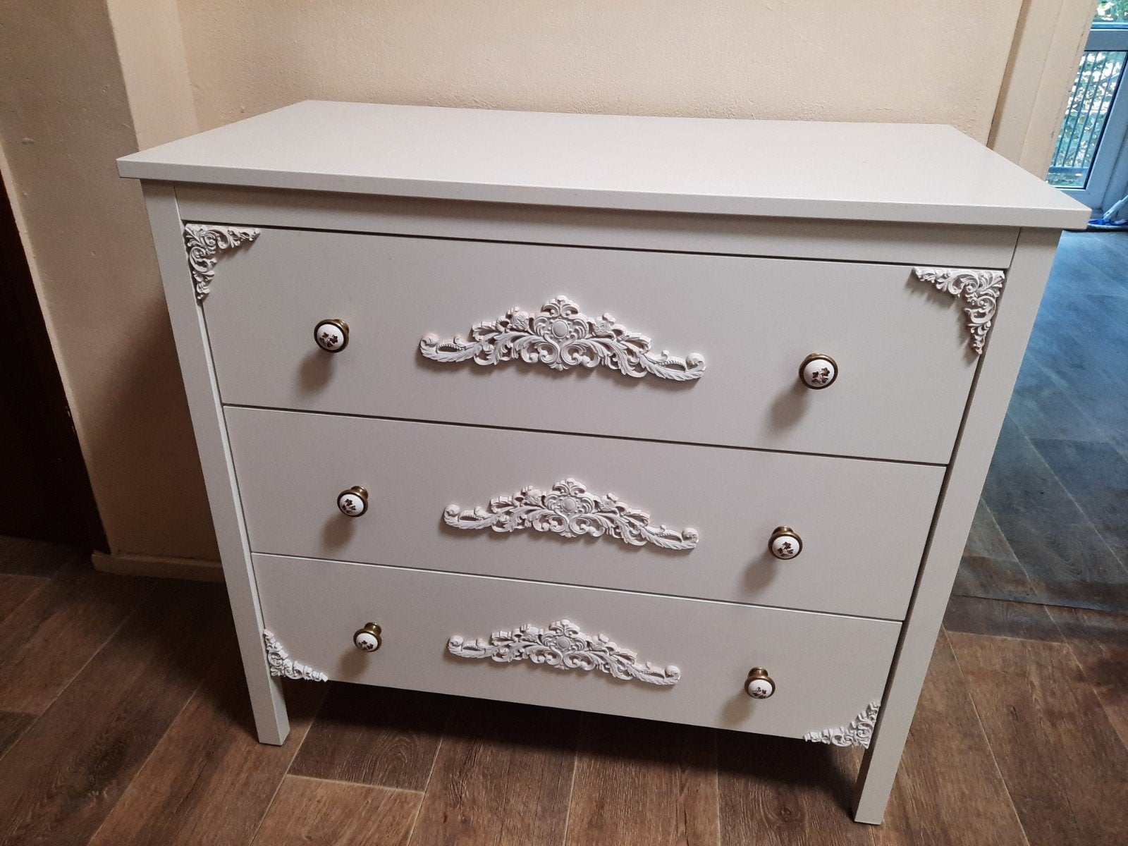 Witte ladekast met barokke ornamenten en vintage handgrepen, Ophalen, 100 tot 150 cm, Klassiek, Sierlijk, 50 tot 100 cm