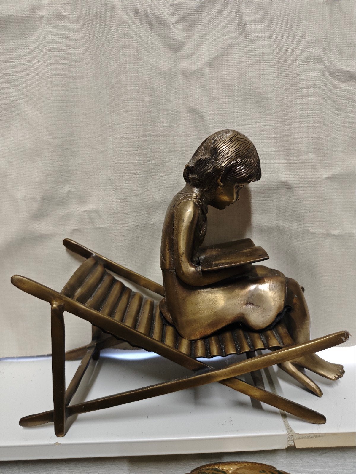 Bronzen beeld van lezend meisje op ligstoel, 30 cm, Ophalen