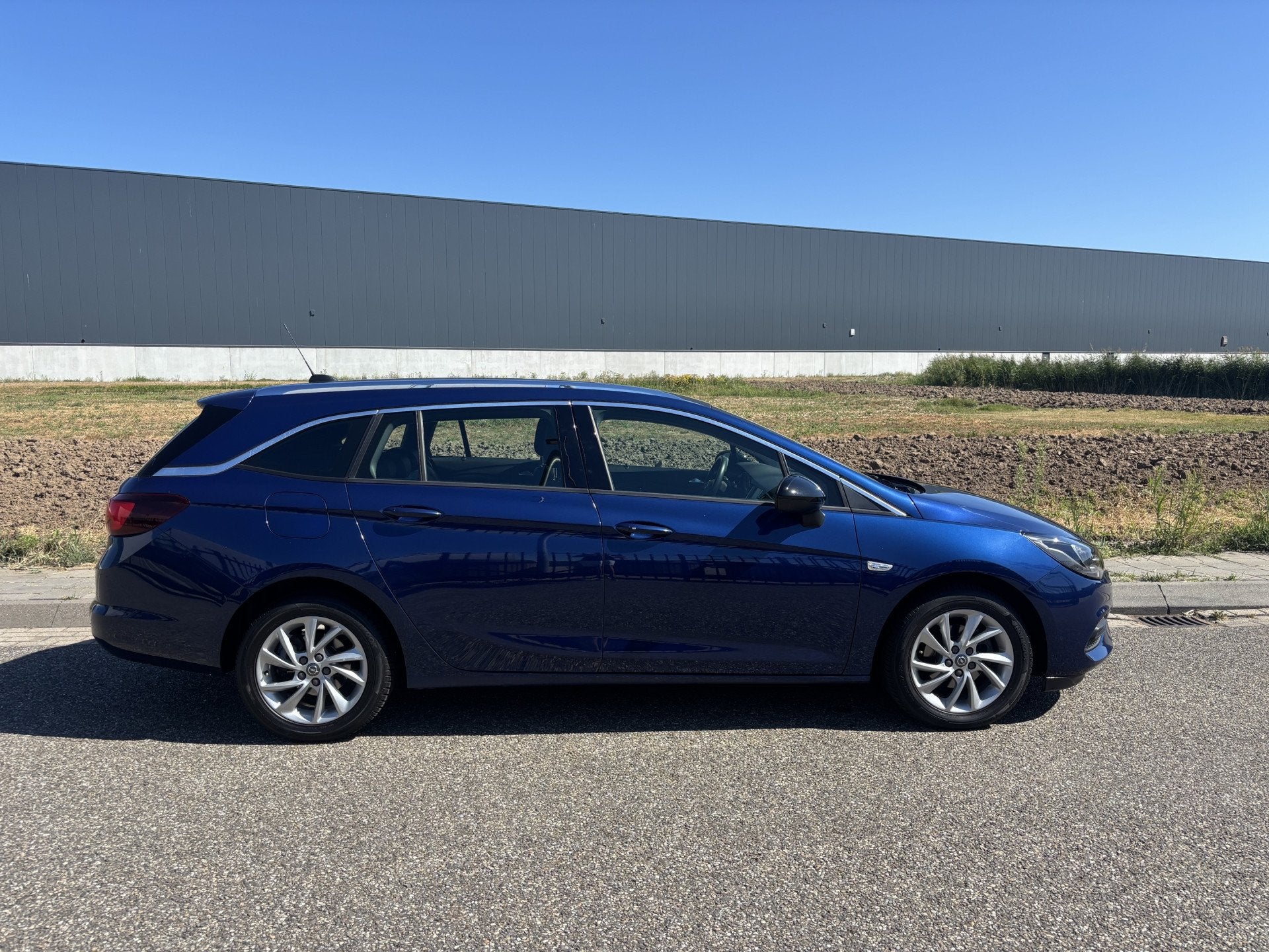 Opel Astra Sports Tourer 1.2 Business Elegance Dealer onderh, Auto's, Gebruikt, Euro 6, 1199 cc, Blauw