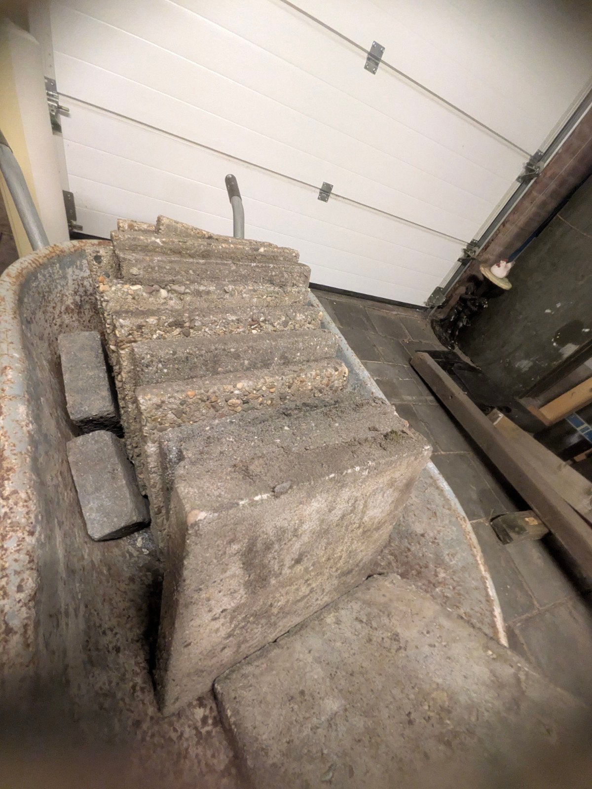 Gebruikte betonblokken en bakstenen in kruiwagen, Ophalen