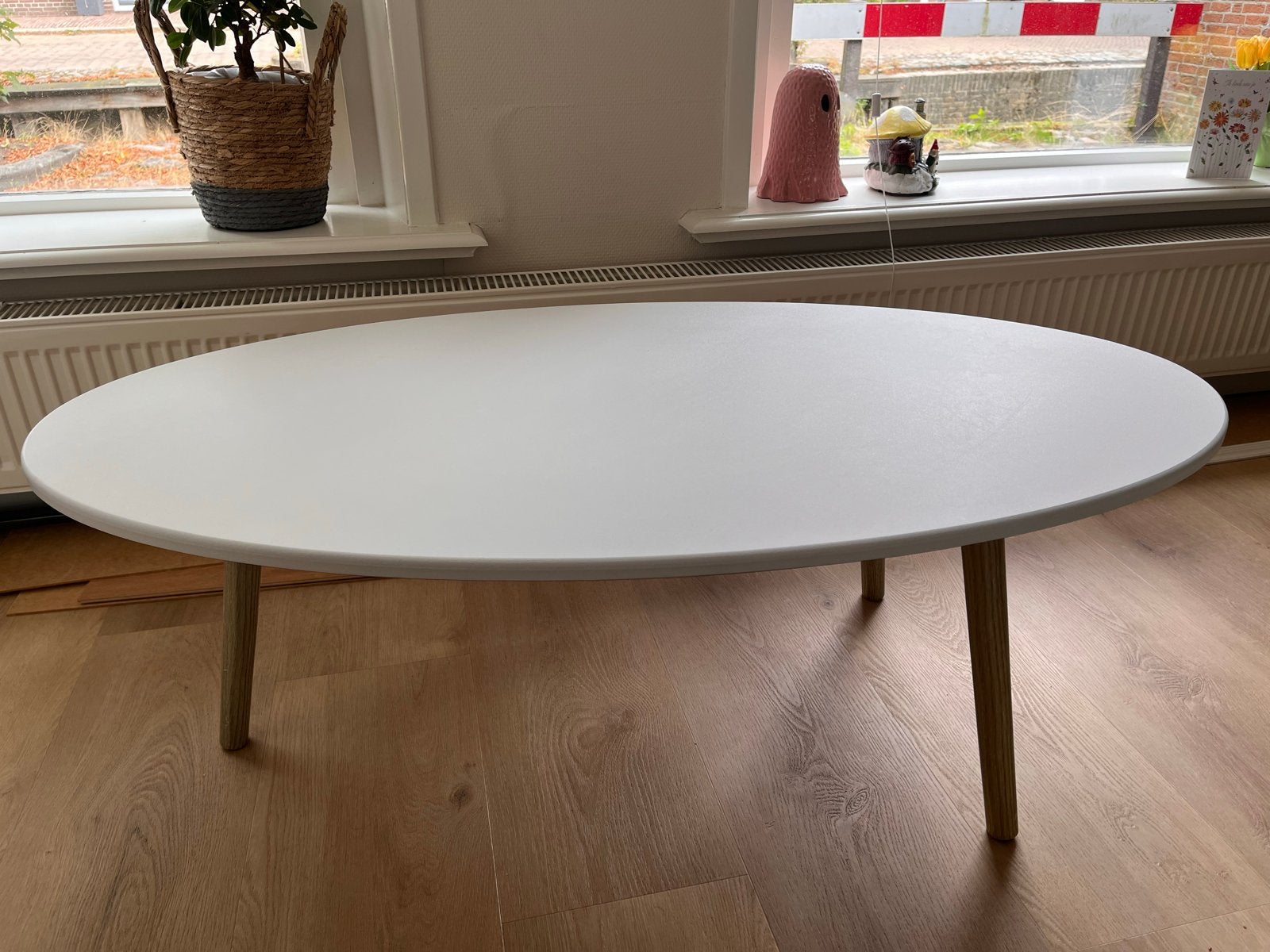 Witte ovale salontafel met houten poten - 110x60x40 cm, Huis en Inrichting, Tafels | Salontafels, Ophalen, Gebruikt, 100 tot 150 cm