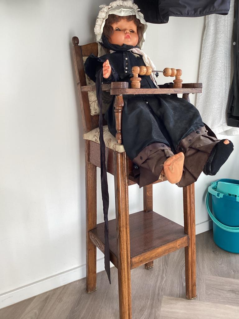 Antieke pop in klederdracht met kinderstoel, Verzamelen, Poppen, Ophalen of Verzenden, Gebruikt, Pop