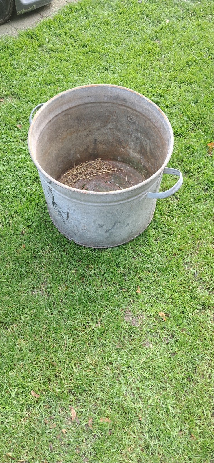 Oude zinken teil met kapotte bodem, Ophalen