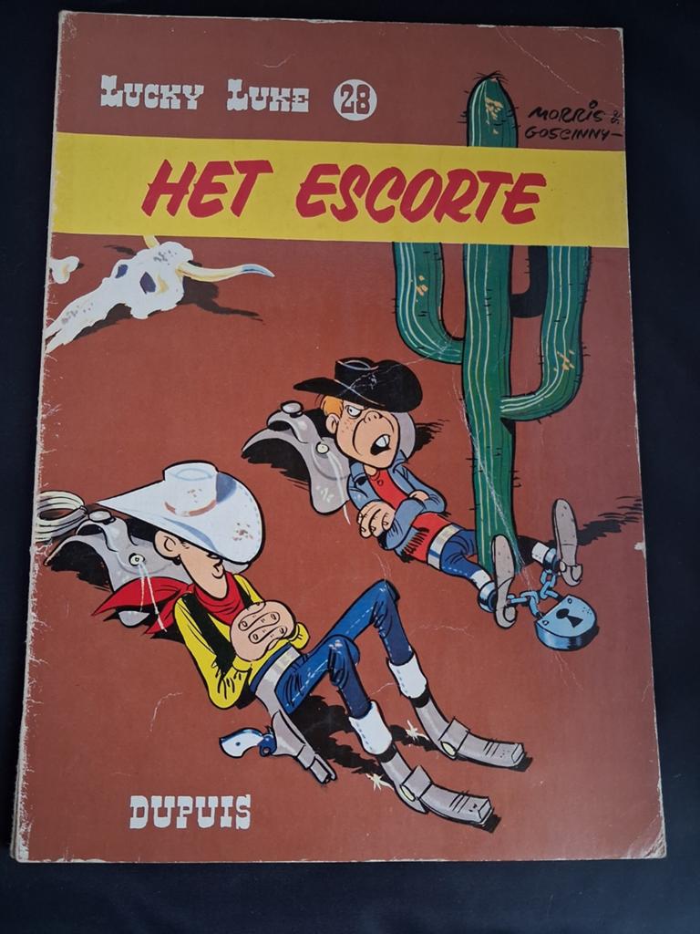 Lucky Luke 28 - Het escorte (Dupuis) 1977, Gelezen, Eén stripboek, Ophalen of Verzenden, Morris & Goscinny