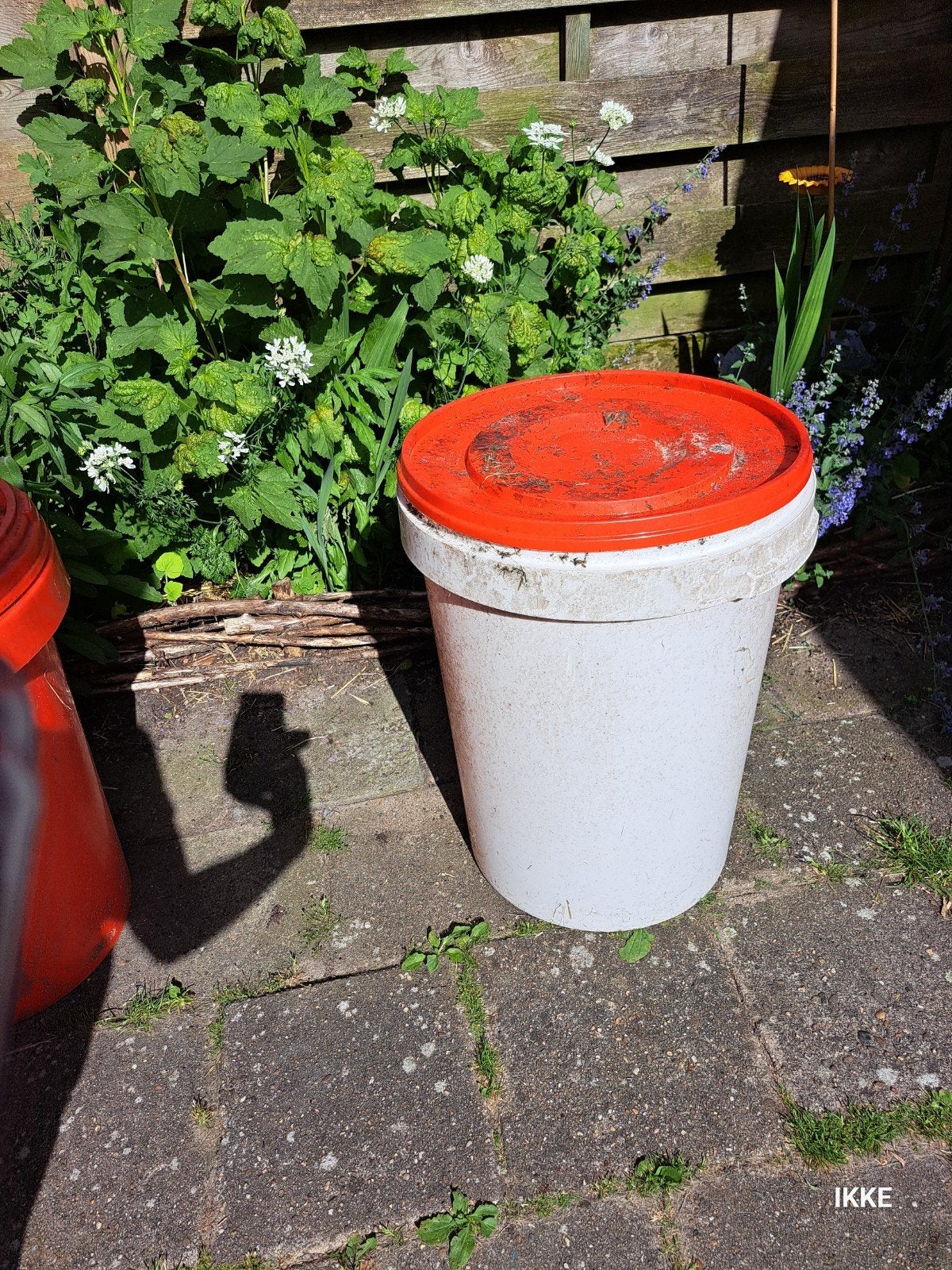 Witte plantenbak met oranje deksel, Ophalen