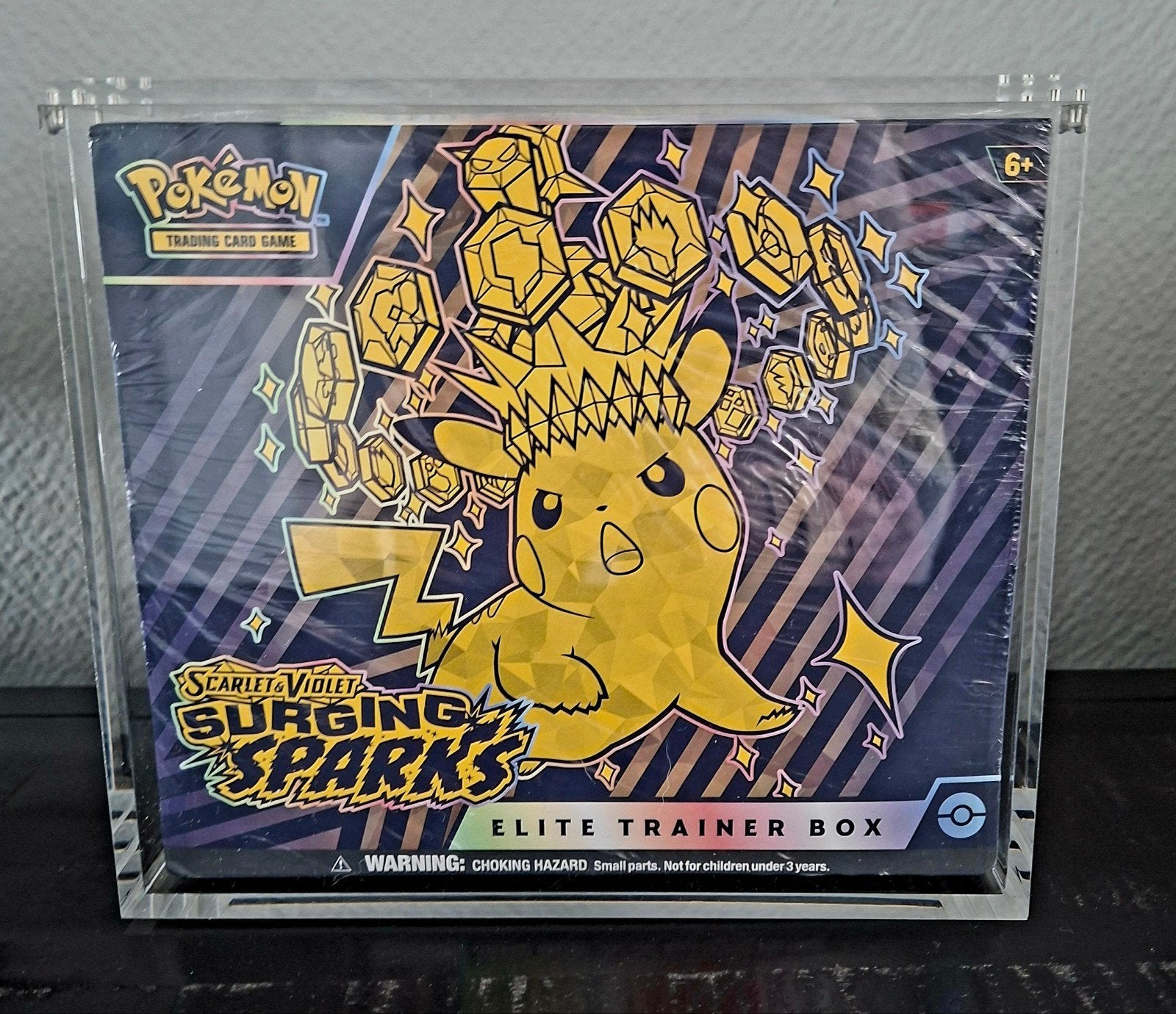 Pokémon TCG: Scarlet & Violet Surging Sparks in ACRYL CASE, Ophalen of Verzenden, Nieuw, Boosterbox, Foil