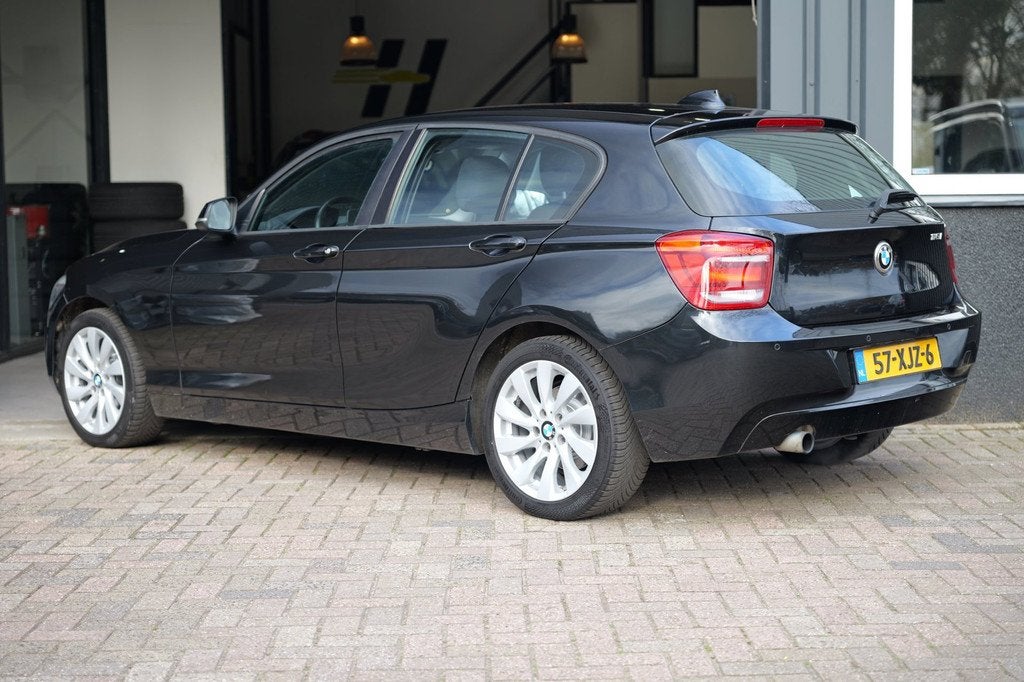 BMW 1-serie 116i Business AUT|Cruise C|LM velgen|Navi|Trekh, Auto's, BMW, Euro 5, Gebruikt, Zwart, 4 cilinders
