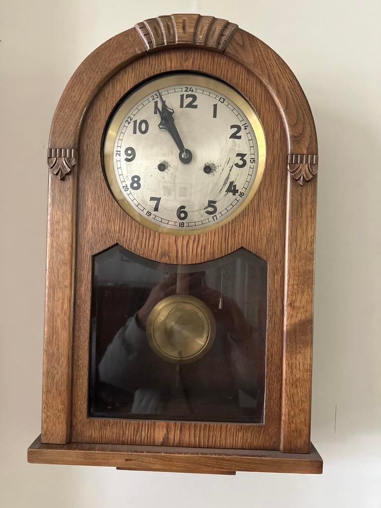 Houten oude wandklok met slinger, Ophalen