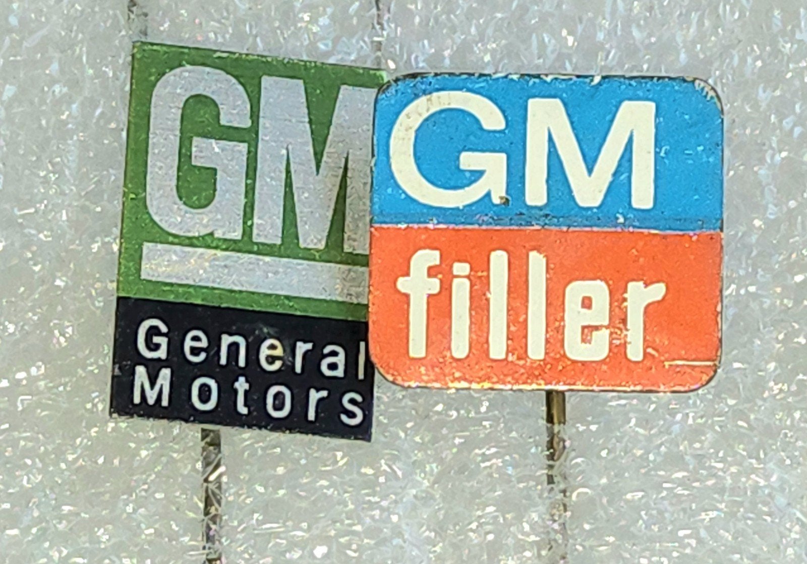 2 Speldjes: Vintage GM General Motors & GM Filler, Verzamelen, Ophalen of Verzenden, Gebruikt, Overige onderwerpen, Speldje of Pin