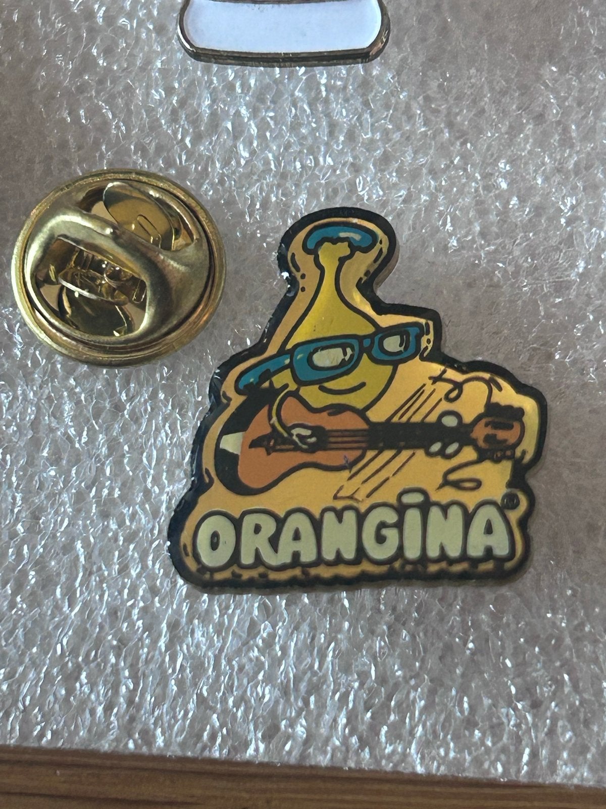Orangina Pin met gitaarspelende fles, Verzamelen, Ophalen of Verzenden, Gebruikt, Merk, Speldje of Pin