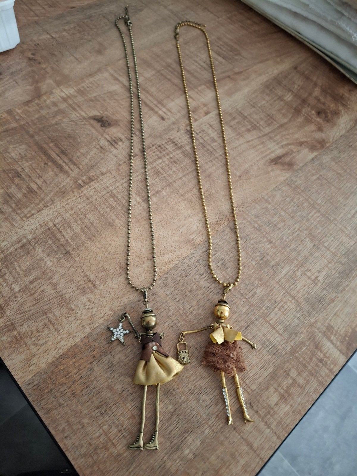 2 lange kettingen met poppetjes hangers, Overige materialen, Ophalen of Verzenden, Zo goed als nieuw, Goud