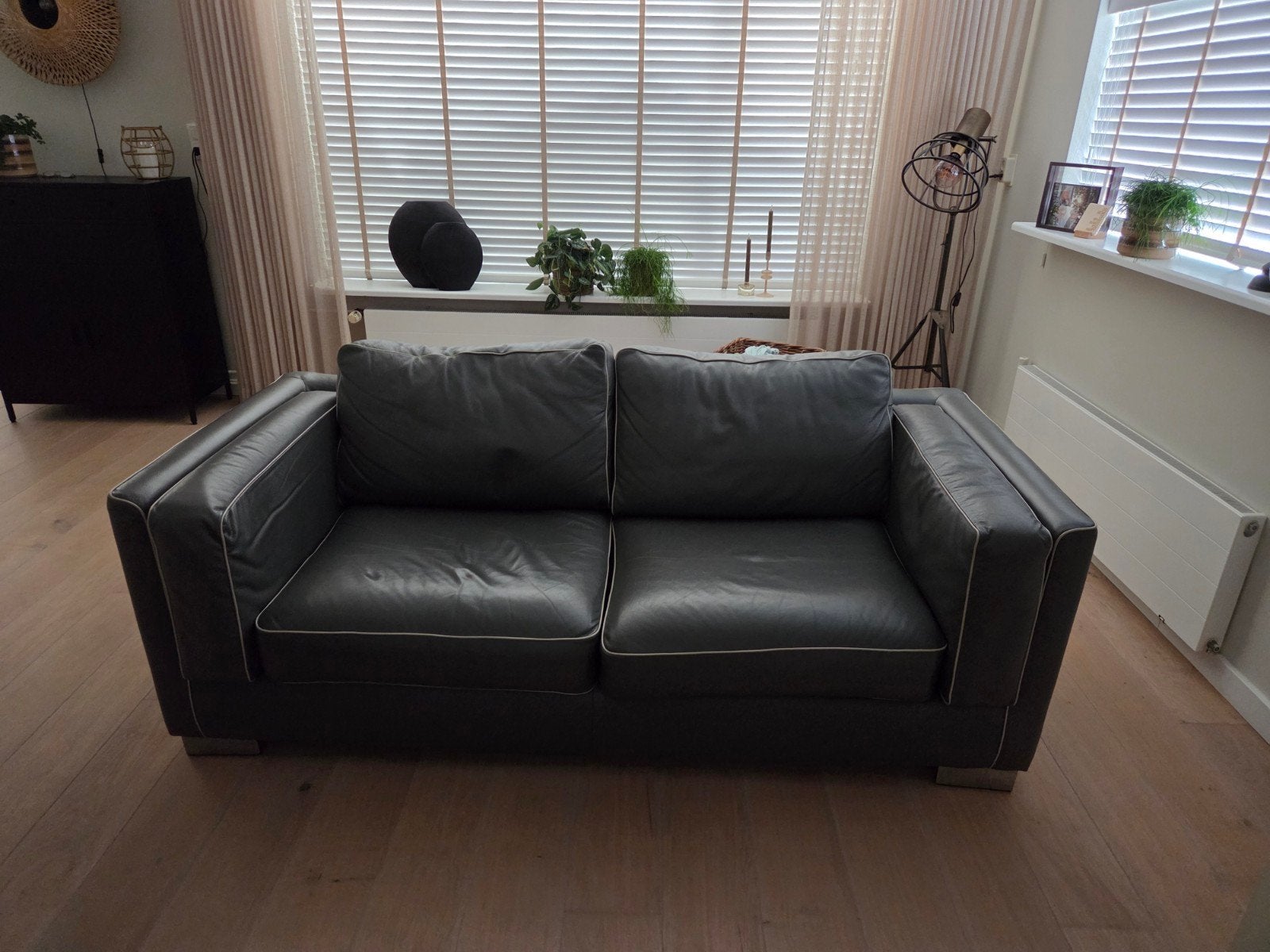 Te koop 2 en 2,5 zits donkergrijze leren bank met witte bies, Huis en Inrichting, Banken | Bankstellen, Gebruikt, Minder dan 75 cm