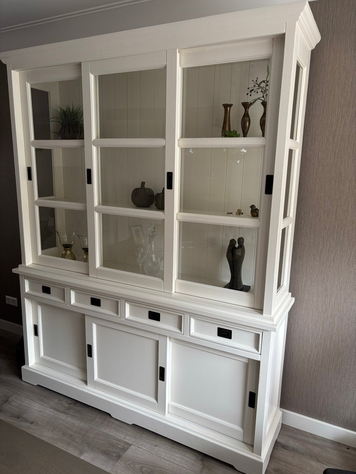 Witte vitrinekast met glazen schuifdeuren en lades