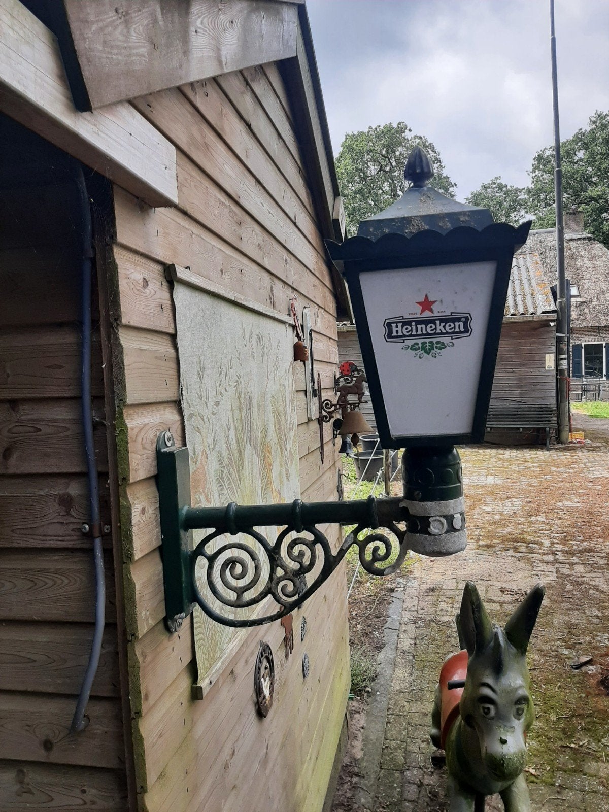 Heineken buitenlamp met sierlijke wandbeugel, Ophalen