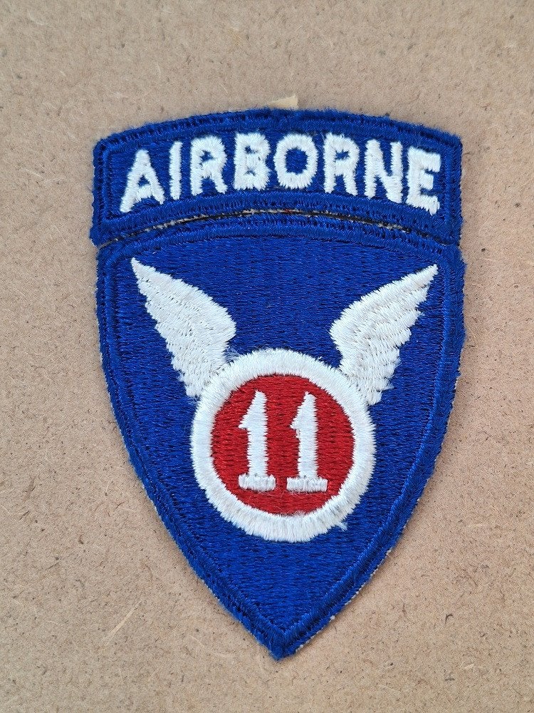 WWII US 11th Airborne Division patch with tab, Verzamelen, Verzenden, Amerika, Embleem of Badge