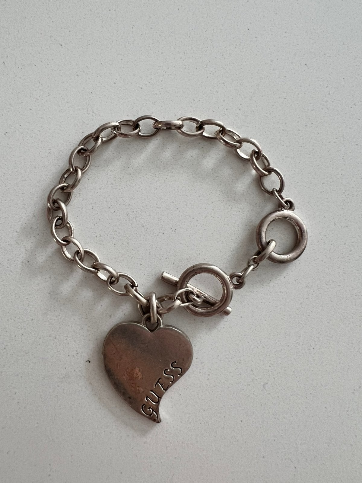 GUESS VINTAGE ZILVERKLEURIGE SCHAKELARMBAND MET HART BEDEL, Gebruikt, Staal, Ophalen of Verzenden, Met bedels of kralen