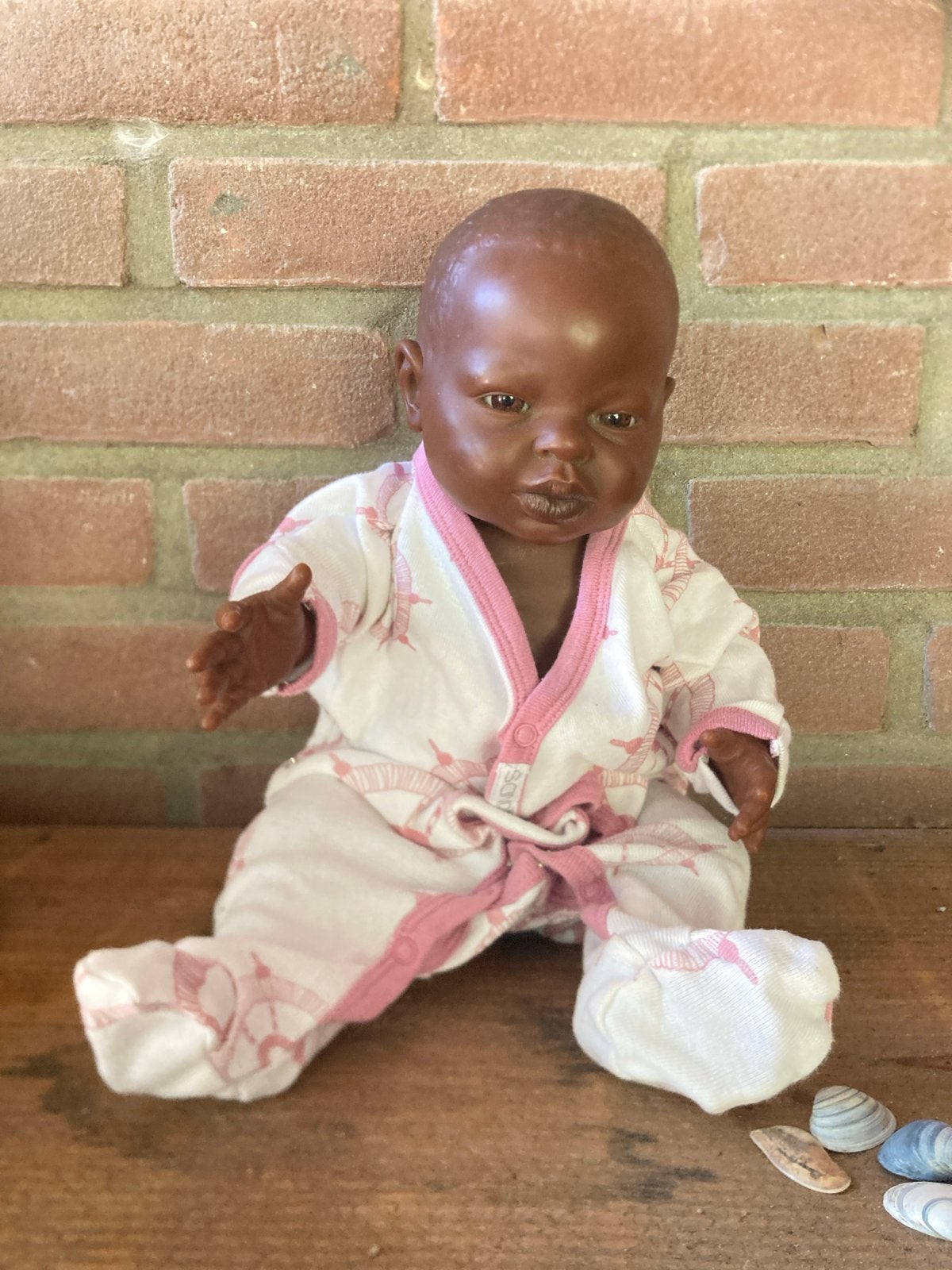 Babypop met donkere huidskleur en roze pakje, Ophalen of Verzenden, Gebruikt, Babypop