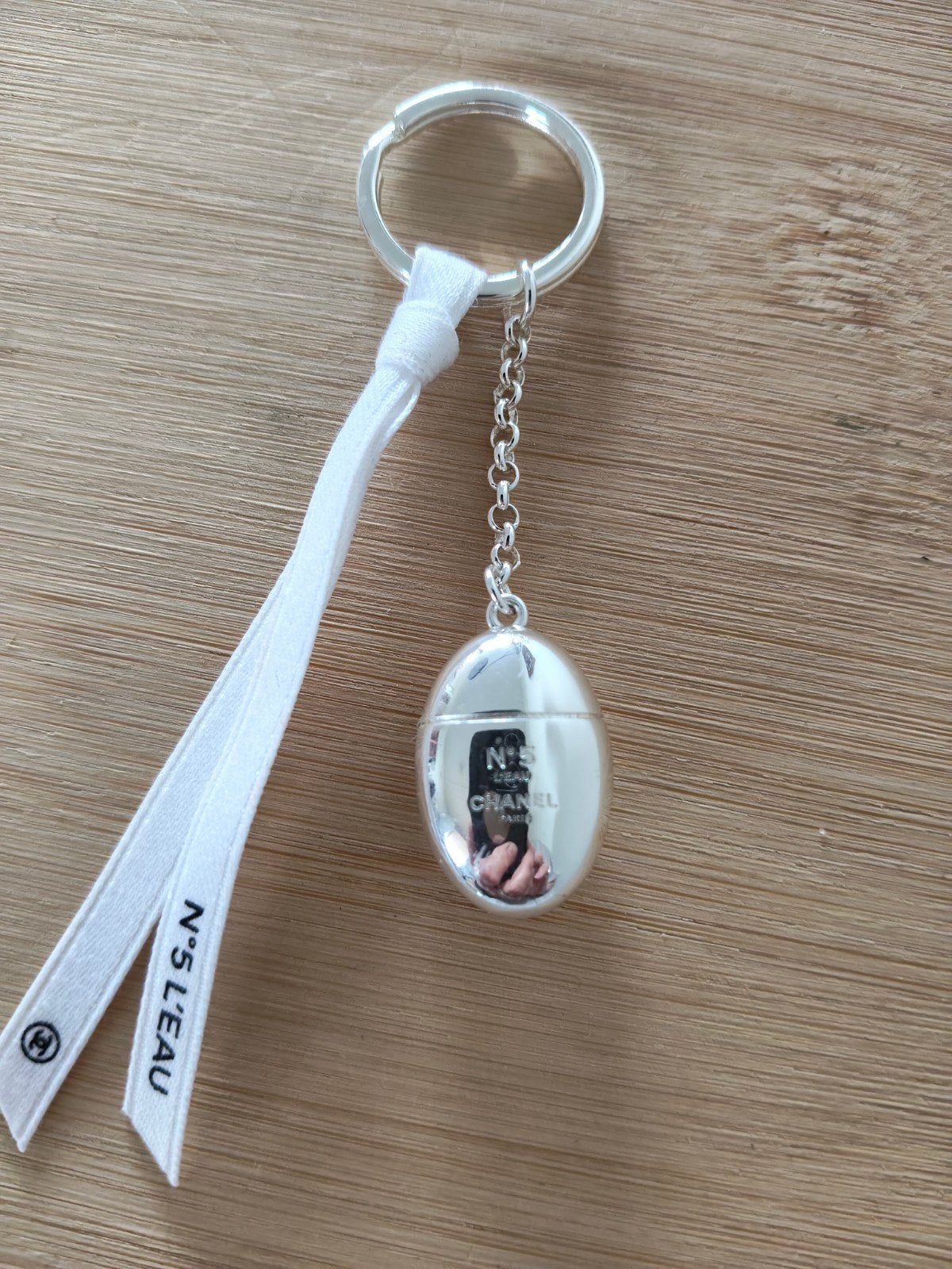 zilverkleurige Chanel N5 L’eau sleutelhanger of tasbedel, Ophalen of Verzenden, Zo goed als nieuw, Merk
