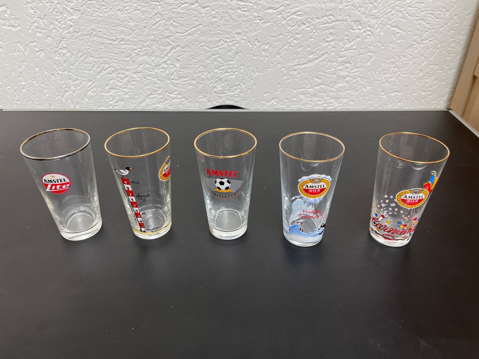 Set van 5 Amstel bierglazen - Diverse edities, Ophalen of Verzenden, Gebruikt, Glas of Glazen, Amstel