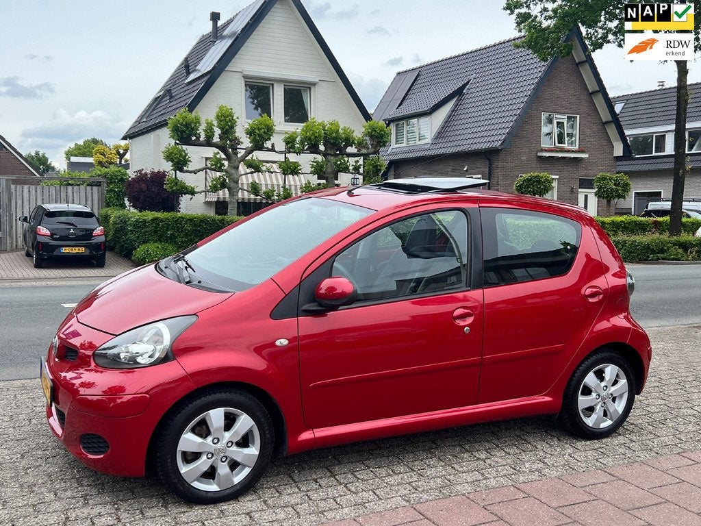 Toyota Aygo 1.0-12V Aspiration Red Navigator NL-AUTO-NAP, Auto's, Voorwielaandrijving, Euro 5, Gebruikt, Zwart